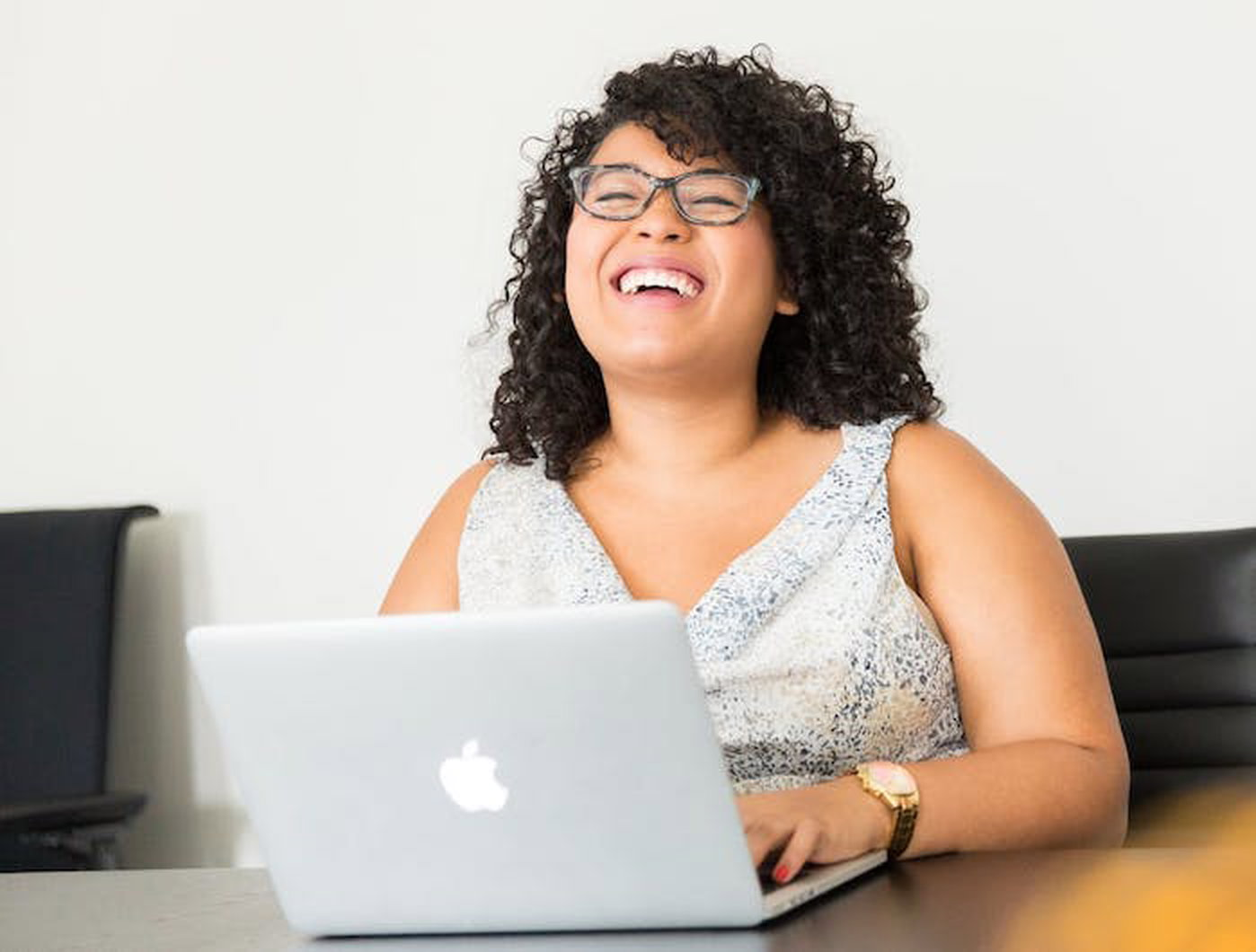 woman laughing at laptop