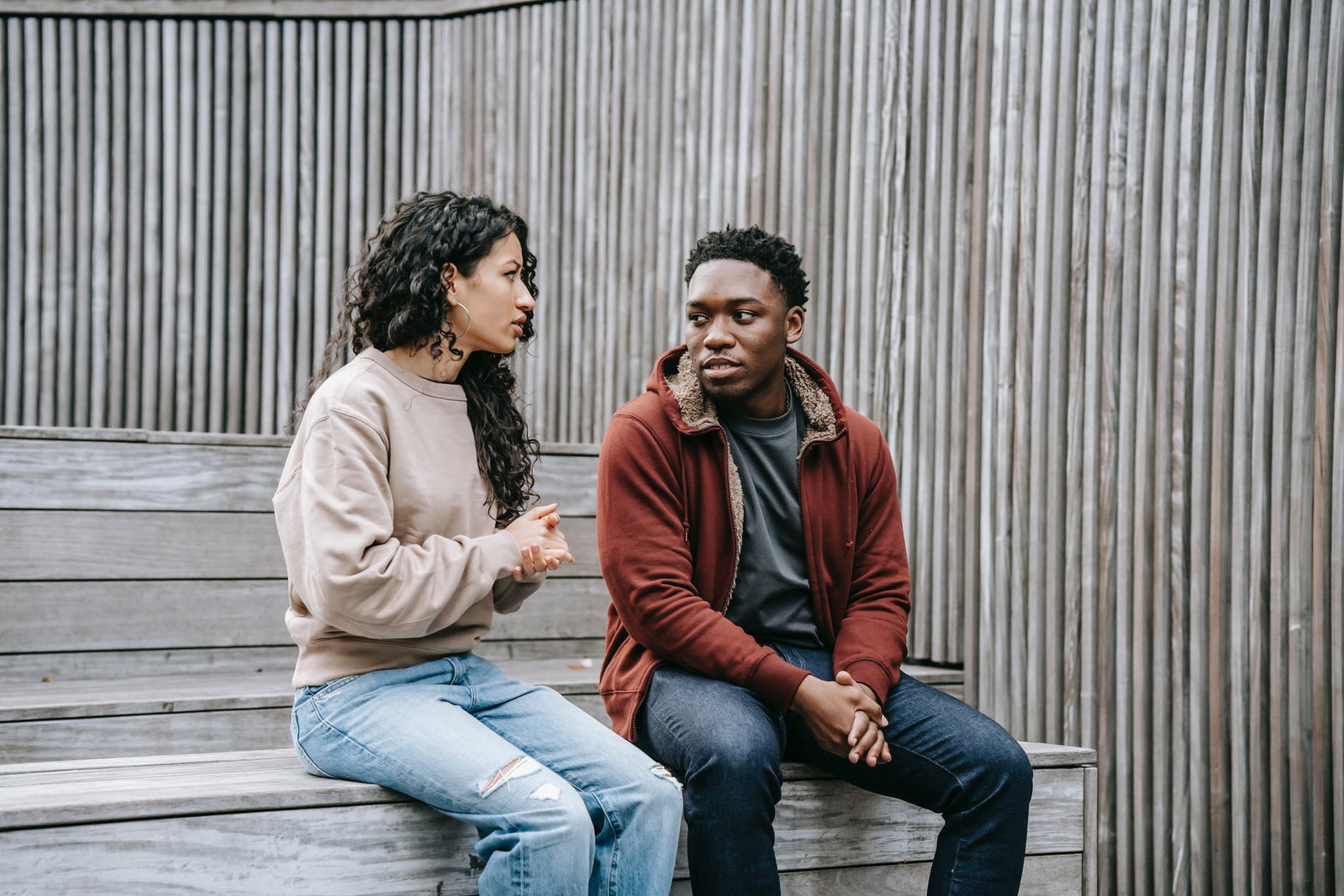 man and woman having serious discussion outside