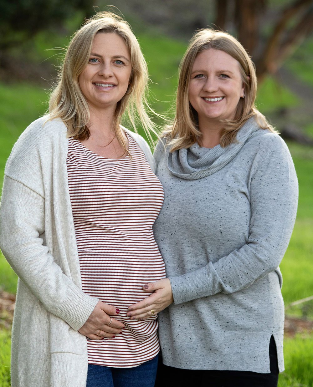 lisa fast smiling as she poses with her pregnant sister for a photo outside.