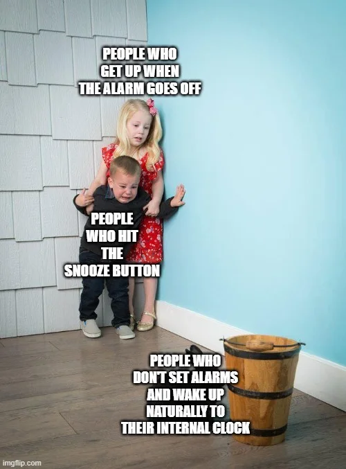 little girl and boy cowering in the corner  from a bunny sitting next to a bucket captioned "people who get up when the alarm goes off, people who hit the snooze button, people who don't set alarms and wake up naturally to their internal clock."