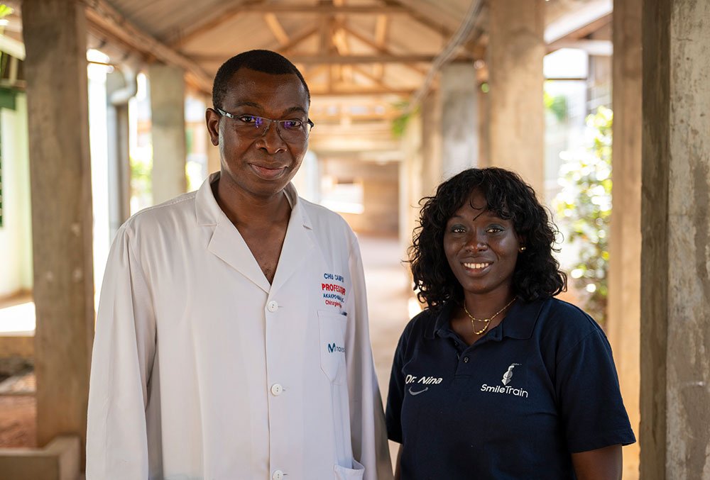 Dr. GrÃ©goire Akakpo-Numado smiling as he poses with a woman named Dr. Nina who is wearing a Smile Train shirt.