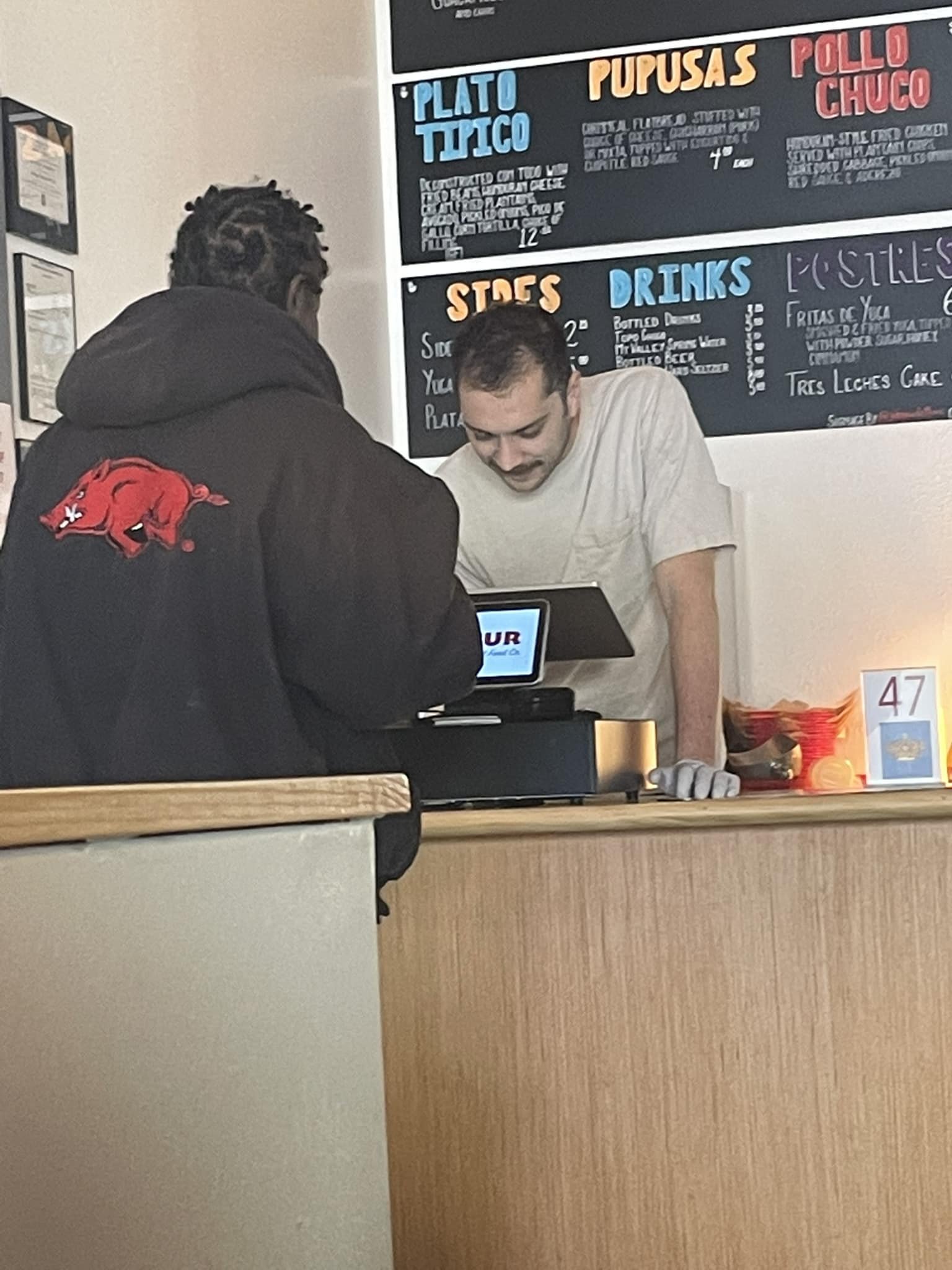 staff member at El Sur Street Food Co offering homeless man a free meal.