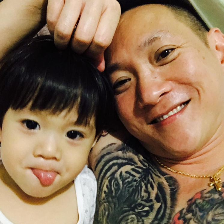 Selfie of Francis smiling with his little girl who is sticking her tongue out.