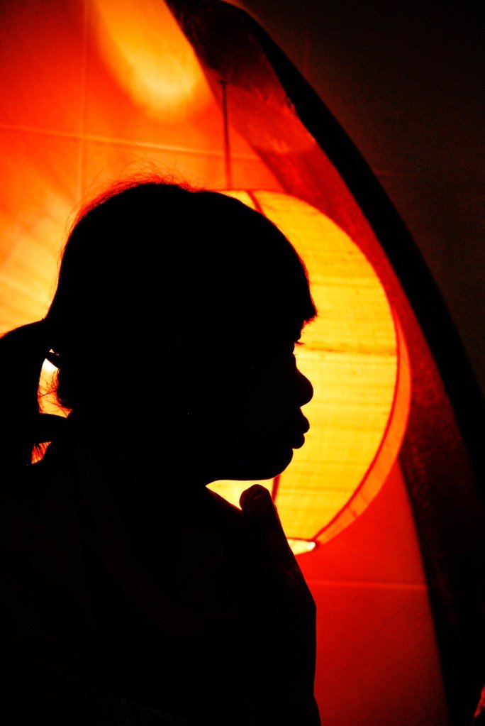 silouette of a little girl against an orange background